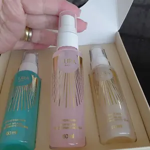 Frasco rosa Aurora Shine segurado à frente do kit